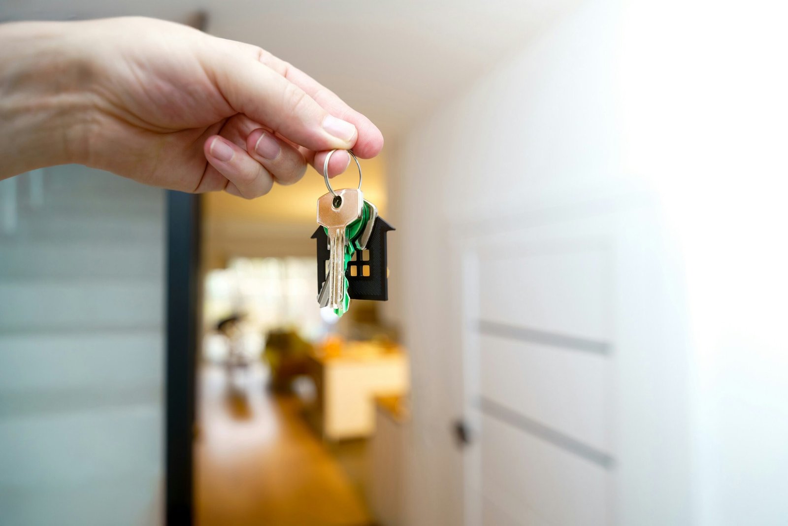Hand holding house keys in front of an open door, symbolizing buying a home in Hanover Township NJ